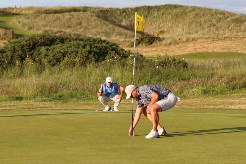 Ryan Riley picks up his ball after qualifying with an eagle